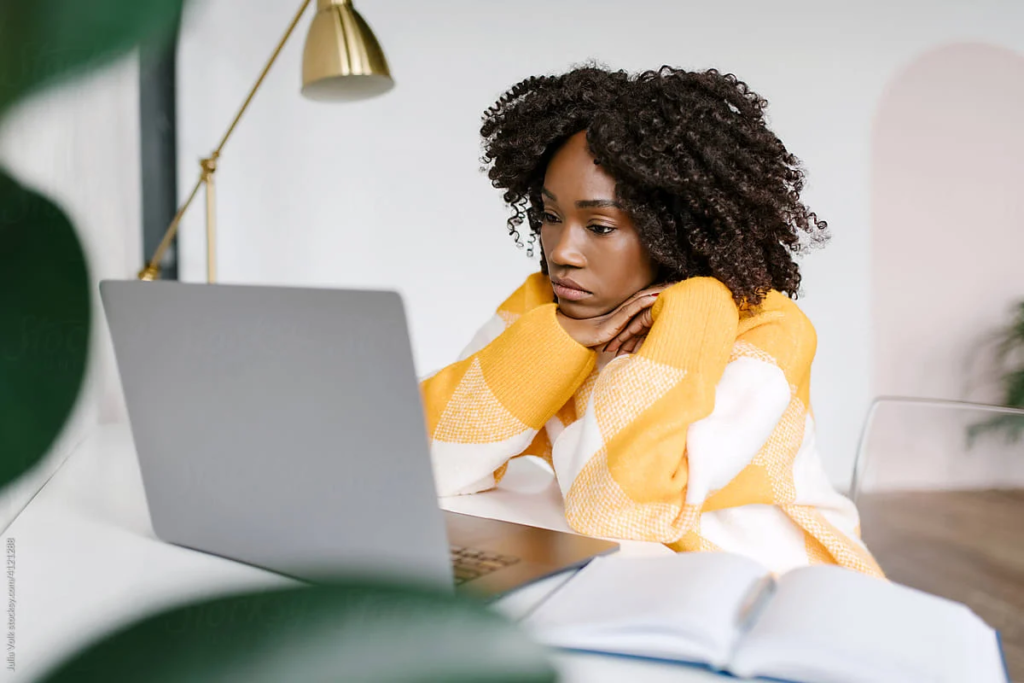 Woman looking out a window, finding motivation to start.